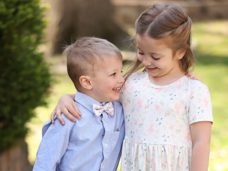 brother and sister laughing together wearing Christian apparel.