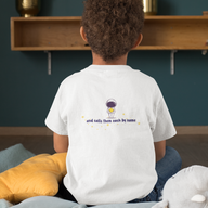 Young boy sitting on cushion with back of white kids Christian tshirt that says "and calls them each by name" below an astronaut holding a star.