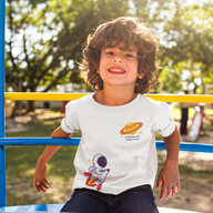 boy sitting on playground with white Christian t-shirt with an outer space theme.