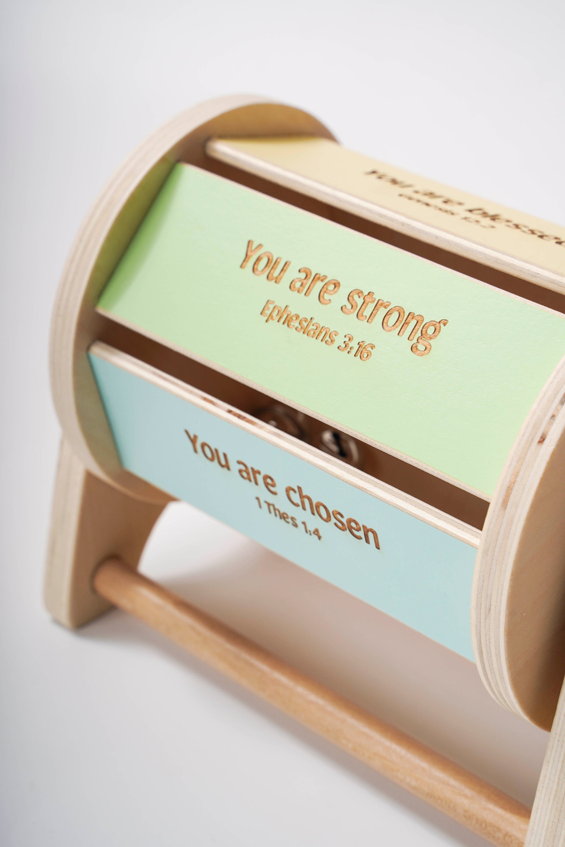 Montessori inspired wooden spinning drum where each panel on the drum features an affirmation bible verse. 'You are strong' is pictured.